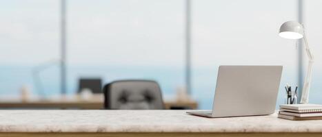 A back view image of a laptop computer on a white marble desk in a modern spacious office. photo