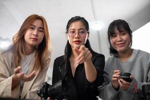 A professional Asian female photographer and her team are looking at the camera. photo