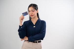 An attractive woman is posing with a credit card while standing against a white studio background. photo