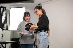 un fotógrafo es demostración imágenes en su cámara a Arte directores, trabajando con su equipo en el estudio foto