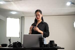 un hembra fotógrafo es preparando su de la cámara lente para un Sesión de fotos, trabajando en un estudio. foto