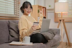 A woman is registering her credit card on a shopping website, enjoying shopping online at home. photo