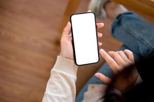 A close-up image of a woman using her smartphone at a table in a cosy cafe. photo