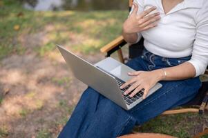 A cropped shot of a female having an online meeting with her team while sitting outdoors. photo