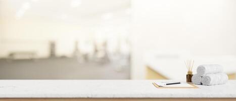 A copy space on a tabletop features a clipboard paper and towels in a modern gym. photo