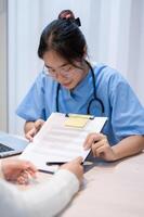 A doctor explaining a medical insurance claim document to a patient during a meeting in the office. photo