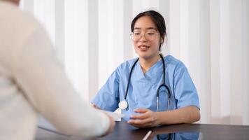 A professional Asian female doctor is working in her office, talking and giving advice to a patient. photo