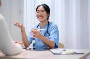 An Asian female doctor is talking with a patient in the office, working at the hospital. photo