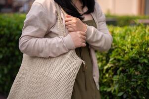 A cropped shot of a happy Asian woman in casual clothes walking in the city. photo