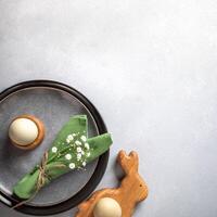 Stylish Easter image with trendy decor in natural colors. Organic eggs, creative plates. Copy space. photo
