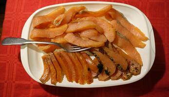 Seasoned and smoked salmon fillet sliced and served photo