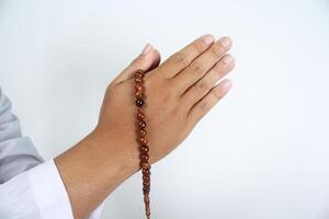 close up of muslim hands posing greeting with holding prayer bead isolated photo