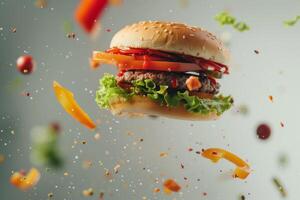 Cheeseburger flying on a gray background with flying ingredients photo