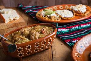 Chicharrones in green sauce, typical mexican food. Mexican food in clay pot. photo