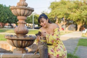 Woman hugging her pet in a public garden at sunset. Dog lover. photo