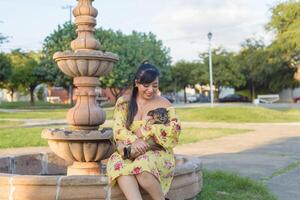 Woman hugging her pet in a public garden at sunset. Dog lover. photo