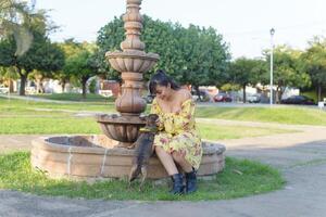 mujer abrazando su mascota en un público jardín a puesta de sol. perro amante. foto