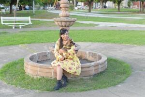 Woman hugging her pet in a public garden at sunset. Dog lover. photo