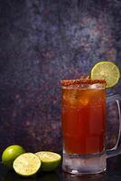 Michelada, typical mexican cocktail on a wooden table. Beer cocktail. photo