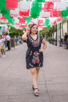 Street portrait of Mexican woman wearing traditional dress with multicolored embroidery. Cinco de Mayo celebration. photo