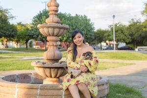 Woman hugging her pet in a public garden at sunset. Dog lover. photo