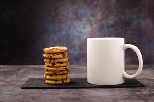 Vanilla chocolate chip cookies next to a white mug. Mockup. photo