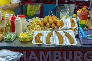 salchichas, brochetas, papas, plátanos, rápido comida a un estar a un mexicano justo. foto