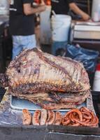 Person grilling meat on a rustic grill in Mexico. Street stall of grilled meat. photo