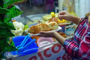 mexicano mujer preparando un hervido maíz, típico mexicano calle alimento. comida parar. elote. foto