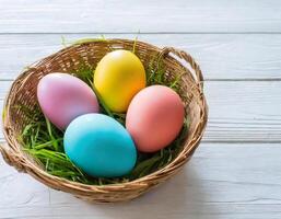 Wicker basket with easter eggs on wooden table. Easter background. photo