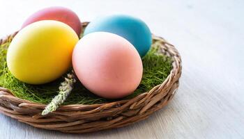 Wicker basket with easter eggs on wooden table. Easter background. photo