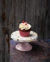 Cupcake on small ceramic plate with wooden bottom with copy space. Product photo. photo