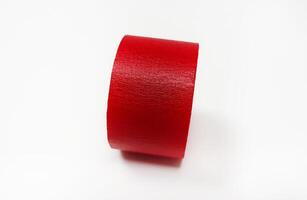 Red masking tape roll isolated on white background. Object for stick on paper. photo