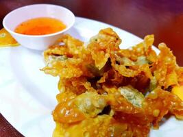 Close up fried dumplings with sweet sauce on white plate. Snack on dish, Asian food style and crispy. photo