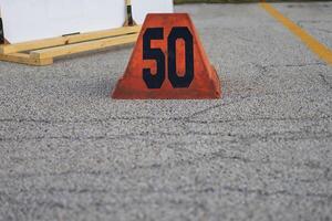 an orange fifty yard line marker ready for a marching band rehearsal photo