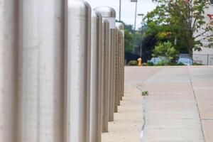 row of traffic barriers protecting a sidewalk and building photo