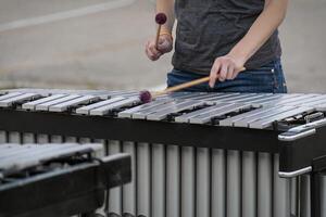 percusionista ensayando para un de marcha banda espectáculo en el temprano noche foto