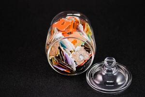 a glass jar filled with lots of multicolored plastic bread tags photo