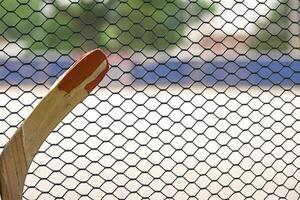 broken hockey stick leaning up against the outside of the rinks mesh photo