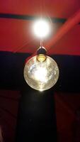 A lit spherical lamp hangs from the ceiling photo