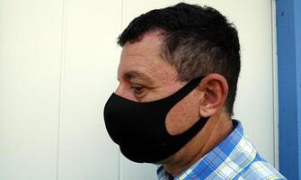 image depicting the face of a man with a black protective anti-contagion mask photo