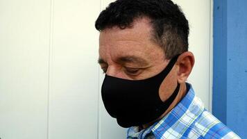 image depicting the face of a man with a black protective anti-contagion mask photo