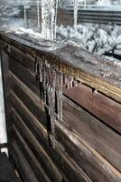 of ice stalactites on the wooden wall photo