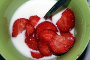 A bowl of yogurt with strawberries ready to be served photo