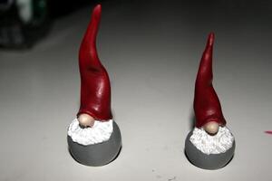 two small statues of two elves dressed in red photo