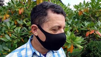 image depicting the face of a man with a black protective anti-contagion mask photo