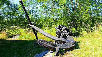 Digital painting style representing a large ancient anchor on the top of a hill photo