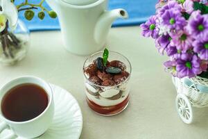 Cup of Tea Next to Vase of Flowers photo