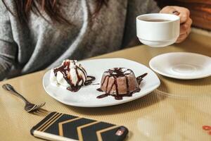 mujer sentado a mesa con plato de postre foto