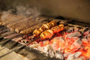 A la parrilla caliente perros y salchichas Cocinando en el parrilla foto